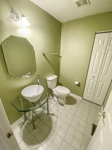 a bathroom with a toilet and a mirror