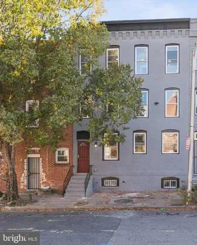 a front view of a house with a tree