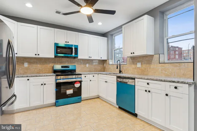a kitchen with granite countertop a sink stainless steel appliances and cabinets