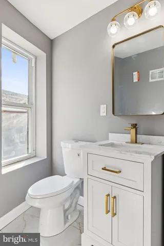 a bathroom with a toilet a sink a vanity and mirror