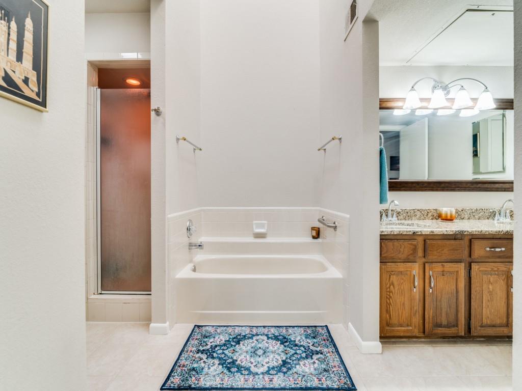 1028 Signal Ridge Place Rockwall, TX 75032 - Photo 14 of 27 a bathroom with a bathtub sink and a mirror