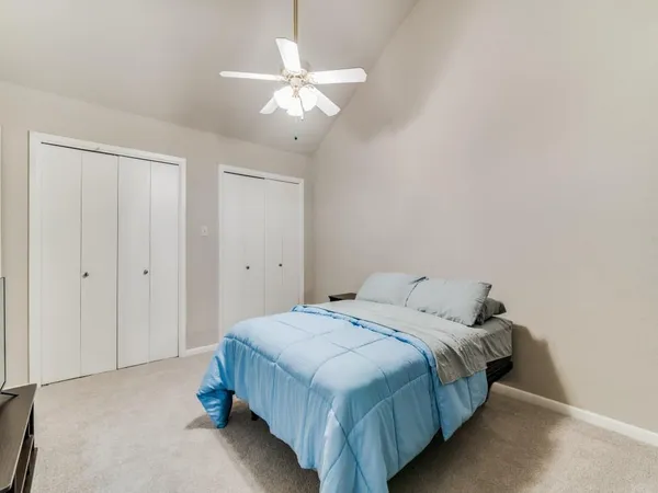a spacious bedroom with a bed and a chandelier