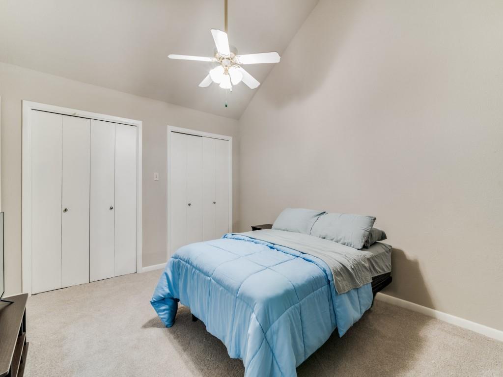 1028 Signal Ridge Place Rockwall, TX 75032 - Photo 23 of 27 a spacious bedroom with a bed and a chandelier