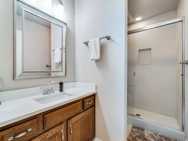 a bathroom with a shower sink and mirror