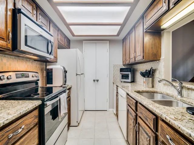 a kitchen with stainless steel appliances granite countertop a sink stove and refrigerator