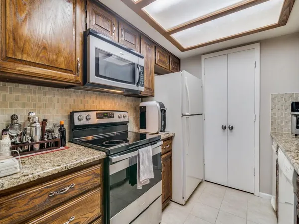 a kitchen with granite countertop cabinets stainless steel appliances and wooden floor