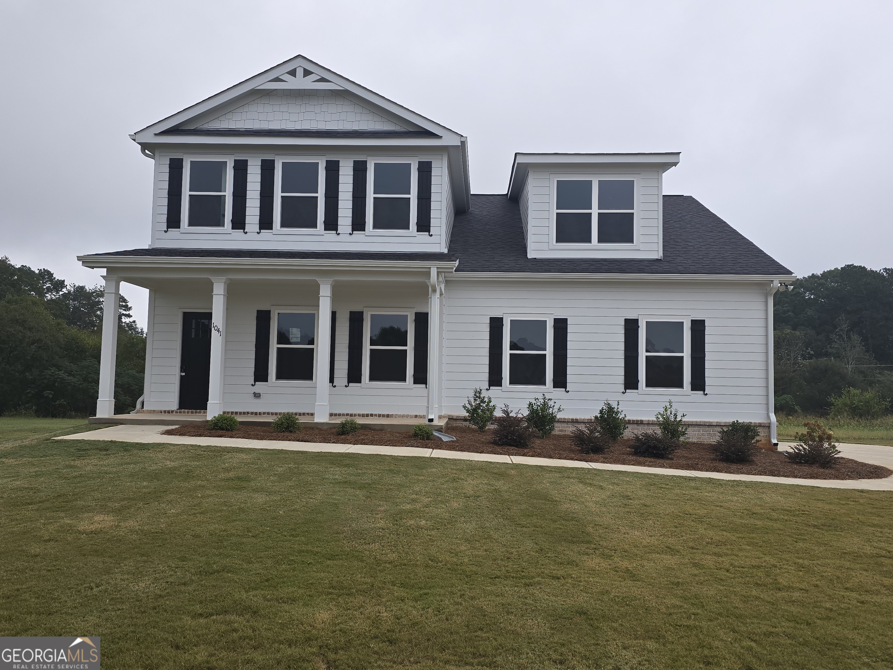 a front view of a house with a garden