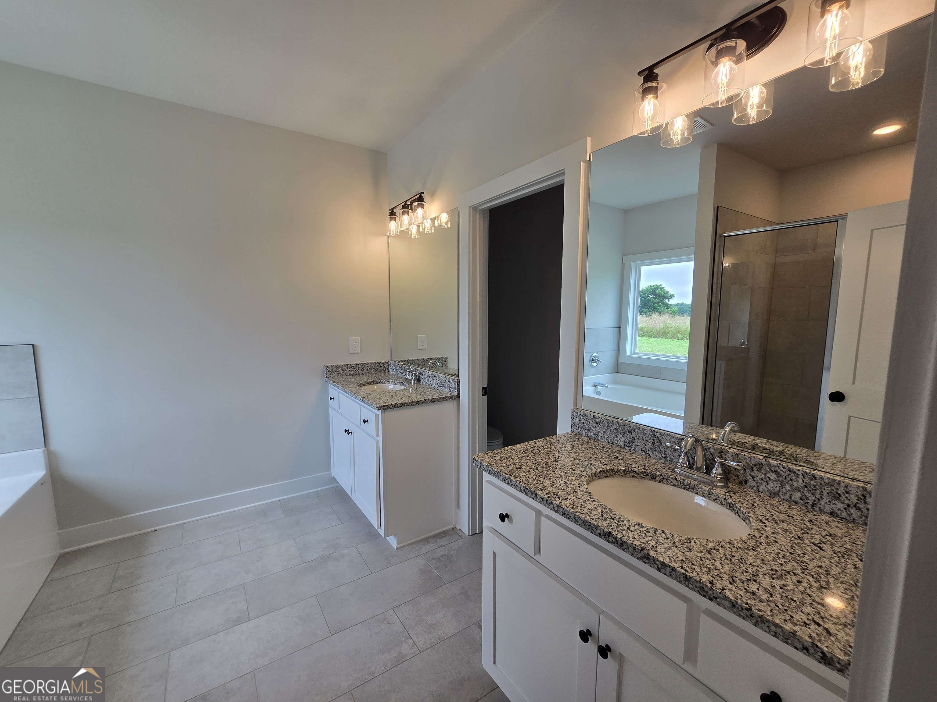 1041 Alaina Avenue, Unit 69 Madison, GA 30650 - Photo 12 of 20 a bathroom with a granite countertop sink and a mirror