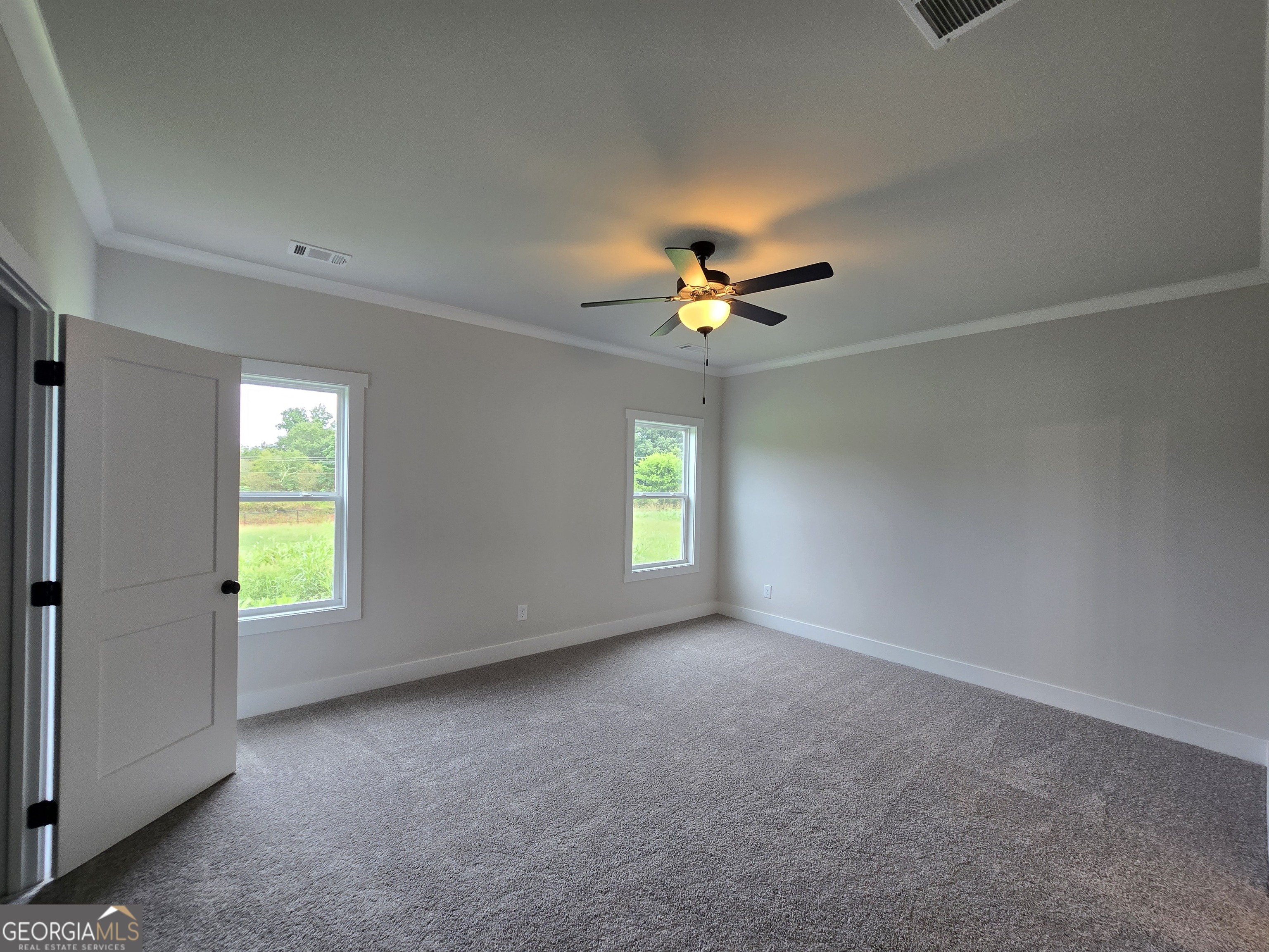 1041 Alaina Avenue, Unit 69 Madison, GA 30650 - Photo 14 of 20 an empty room with windows and chandelier fan
