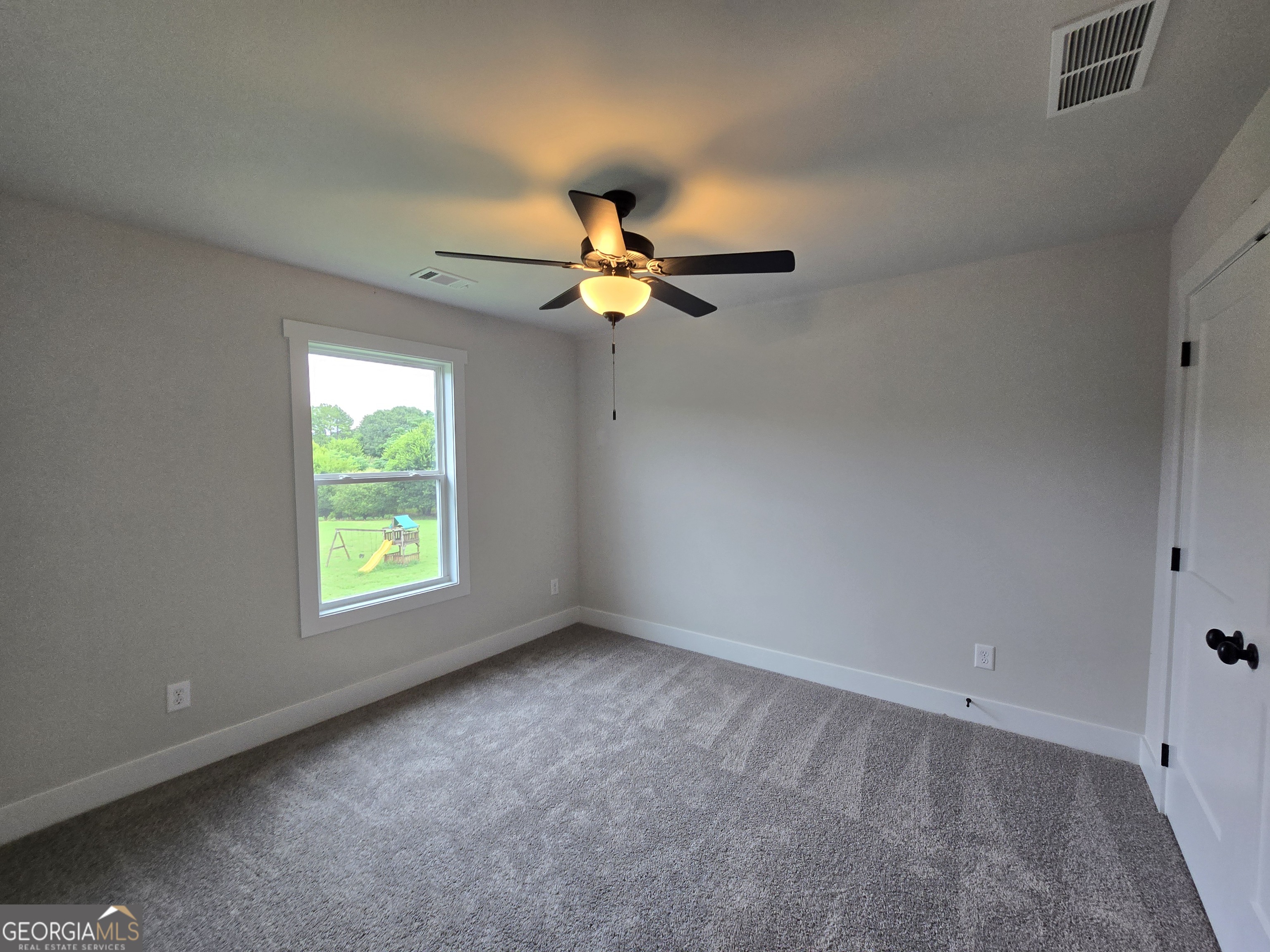1041 Alaina Avenue, Unit 69 Madison, GA 30650 - Photo 18 of 20 an empty room with a window and a fan