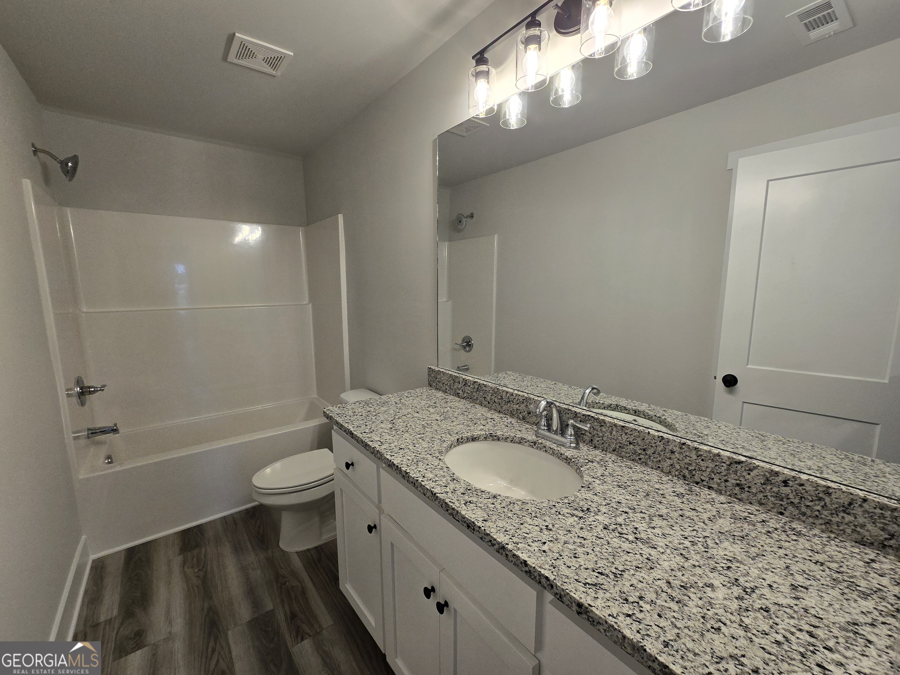 1041 Alaina Avenue, Unit 69 Madison, GA 30650 - Photo 20 of 20 a bathroom with a granite countertop sink toilet and shower