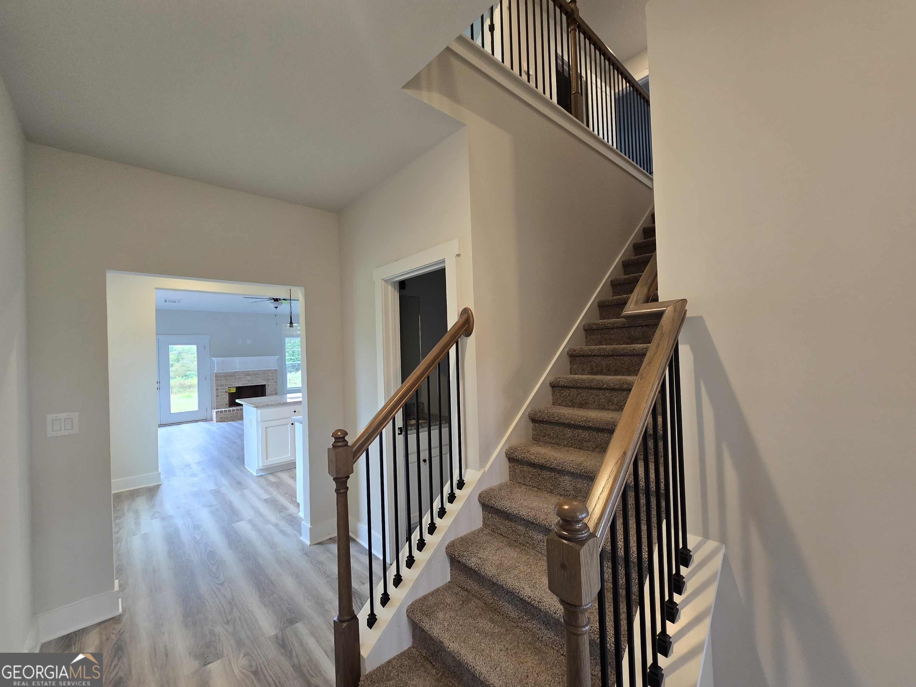 1041 Alaina Avenue, Unit 69 Madison, GA 30650 - Photo 5 of 20 a view of a hallway with wooden floor and stairs
