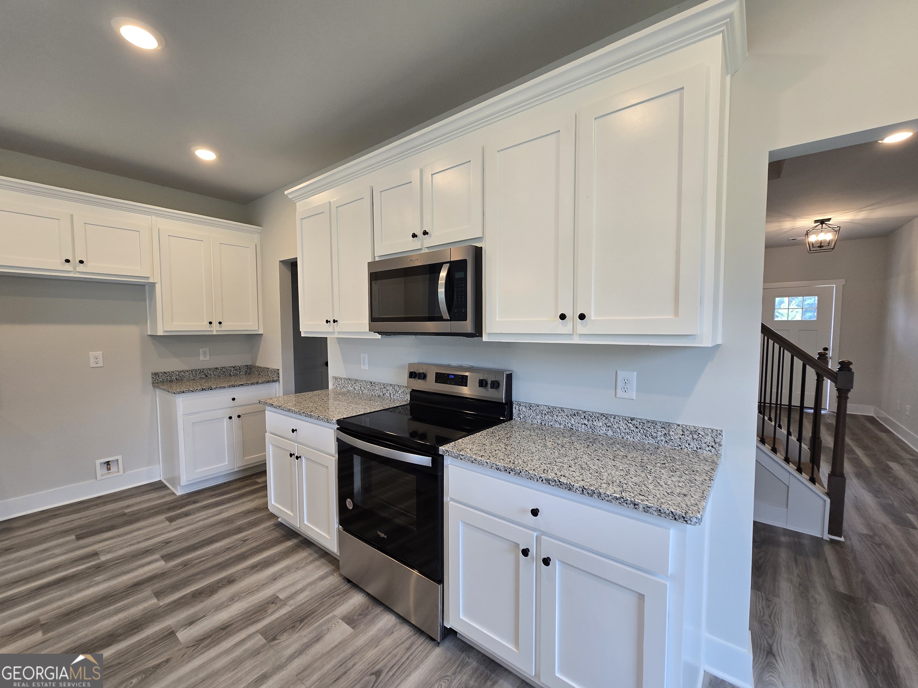 1041 Alaina Avenue, Unit 69 Madison, GA 30650 - Photo 6 of 20 a kitchen with granite countertop white cabinets and stainless steel appliances