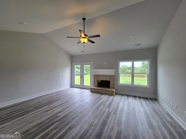 a view of an empty room with a fireplace and a window