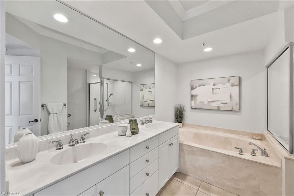 300 Dunes Boulevard, Unit 605 Naples, FL 34110 - Photo 15 of 37 a spacious bathroom with a tub sink and mirror