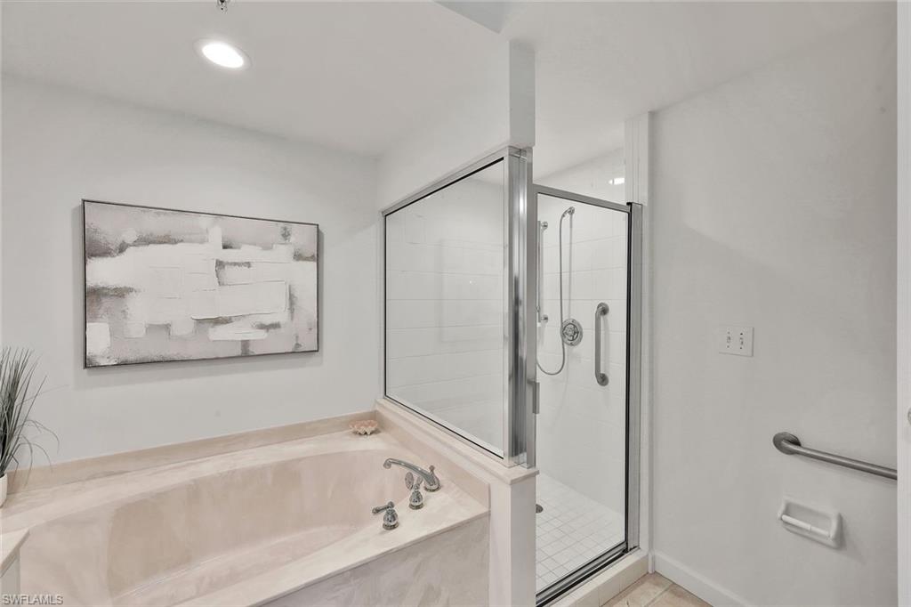 300 Dunes Boulevard, Unit 605 Naples, FL 34110 - Photo 16 of 37 a bathroom with a bathtub and a shower