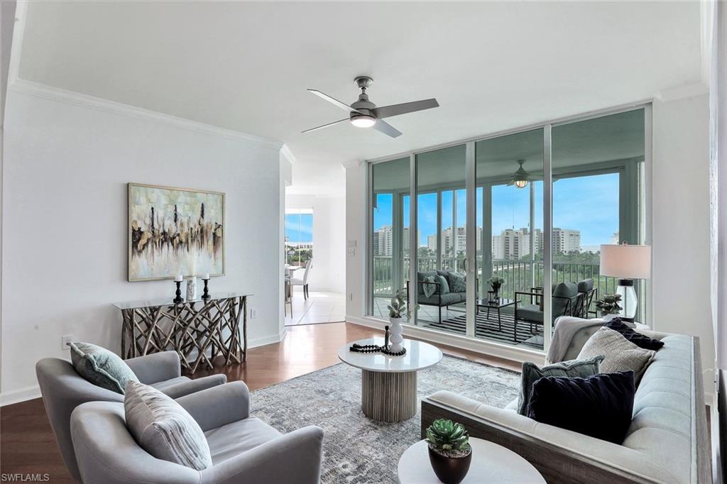 300 Dunes Boulevard, Unit 605 Naples, FL 34110 - Photo 2 of 37 a living room with furniture a large window and a chandelier