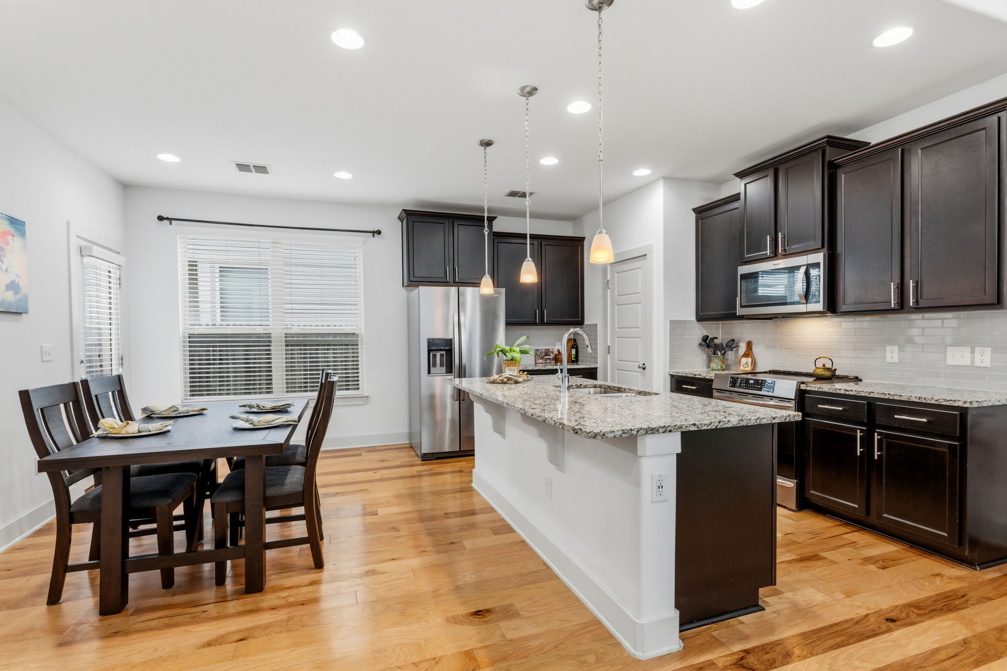 1007 Totis Road Austin, TX 78748 - Photo 15 of 37 a kitchen with stainless steel appliances kitchen island granite countertop a stove a sink a dining table and chairs