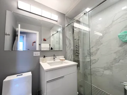 a bathroom with a sink mirror and a toilet