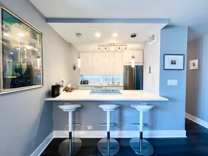 a kitchen with a sink and chairs