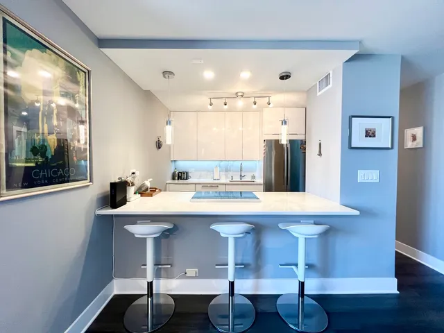 a kitchen with a sink and chairs