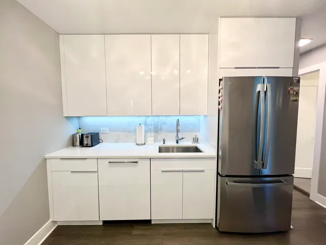 a kitchen with a refrigerator sink and cabinets