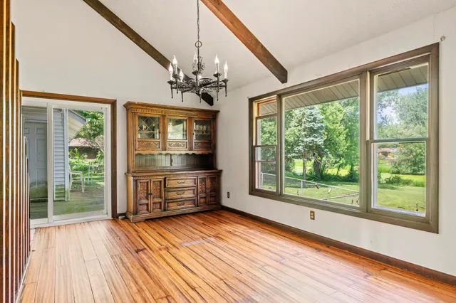 an empty room with wooden floor and natural light