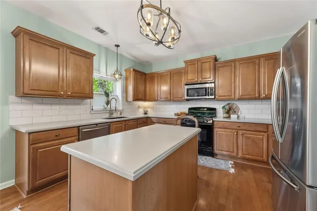 a kitchen with stainless steel appliances granite countertop a sink stove microwave and refrigerator