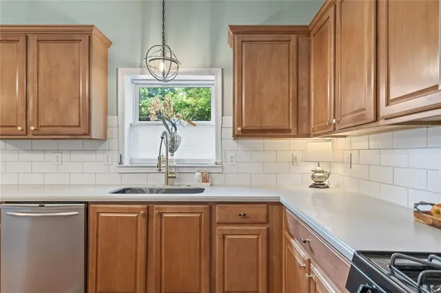 a kitchen with stainless steel appliances granite countertop a sink a stove cabinets and wooden floor
