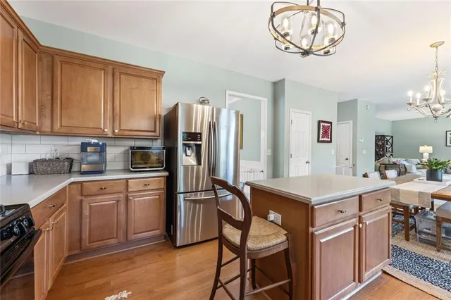 a kitchen with stainless steel appliances a table chairs and a refrigerator