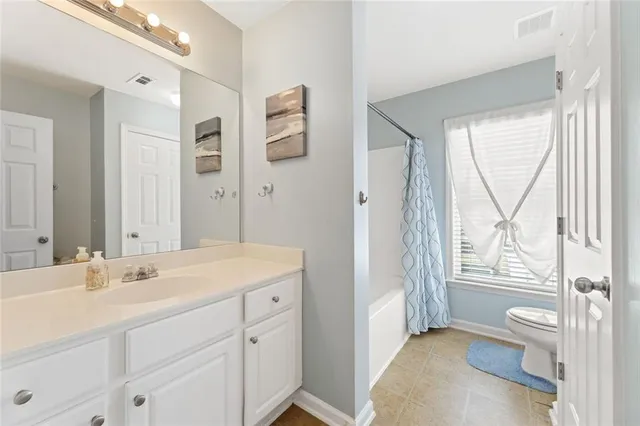 a spacious bathroom with a granite countertop sink toilet and shower
