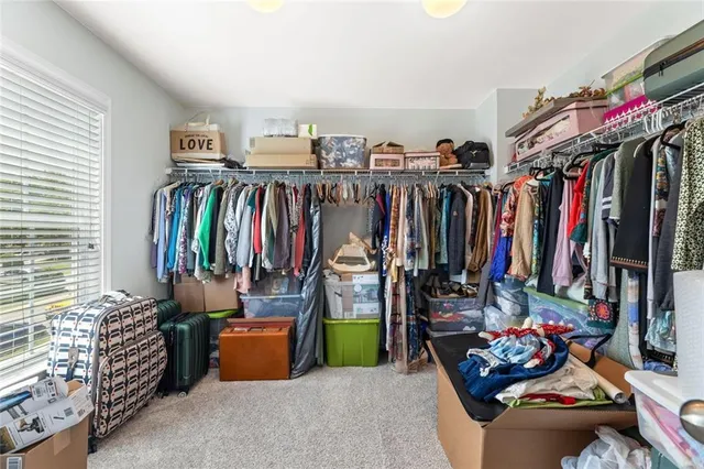 a view of walk in closet with clothes and shoes