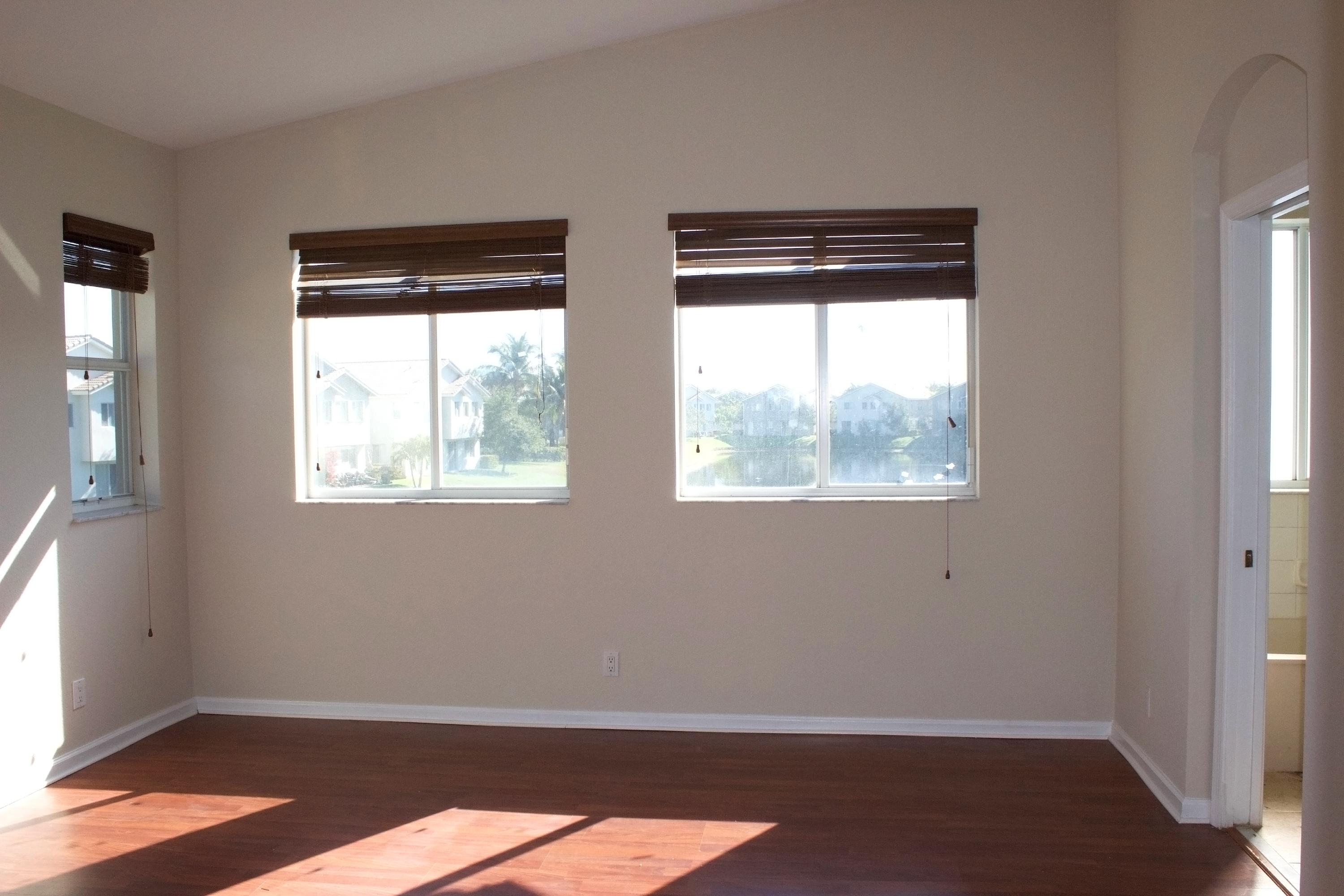 3088 Laurel Ridge Circle Riviera Beach, FL 33404 - Photo 10 of 27 an empty room with wooden floor and windows