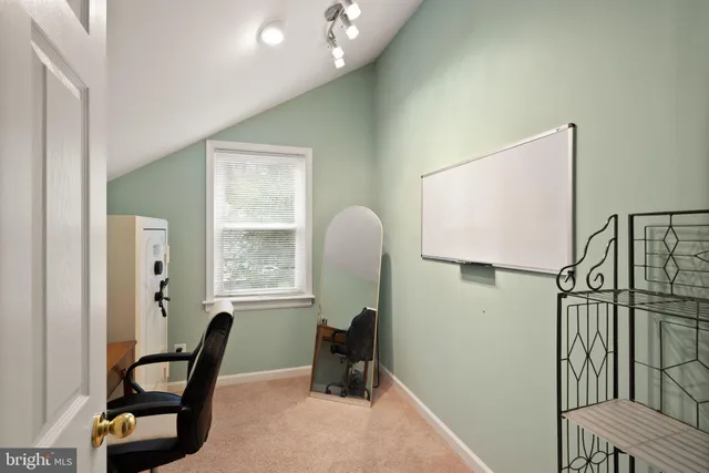 a view of a workspace with furniture and a window