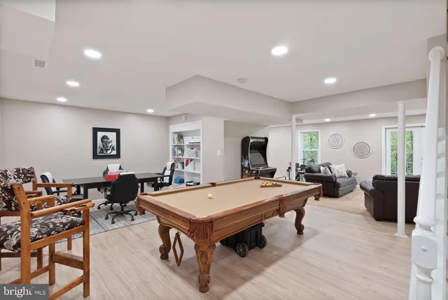 a living room with stainless steel appliances furniture and wooden floor