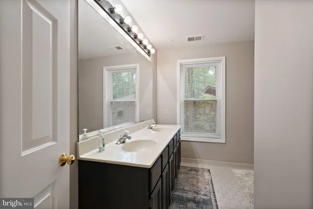 a bathroom with a sink a mirror and a window