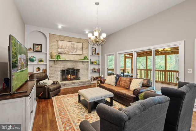 a living room with furniture a large window and a fireplace