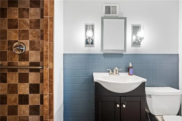 a bathroom with a sink a toilet and a mirror