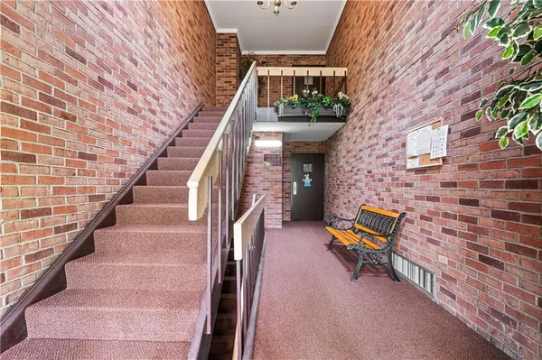 a view of a hallway view with wooden floor and a bathroom