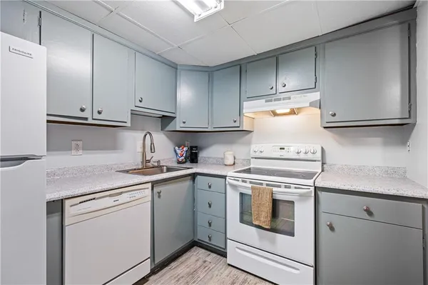 a kitchen with a sink a refrigerator and cabinets