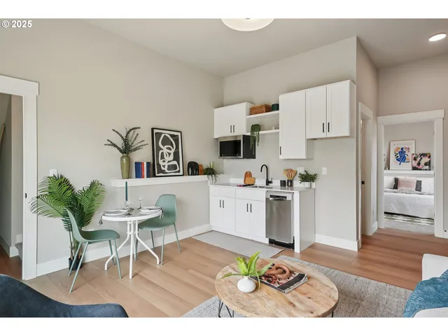 a living room with furniture appliances and a dining table with kitchen view