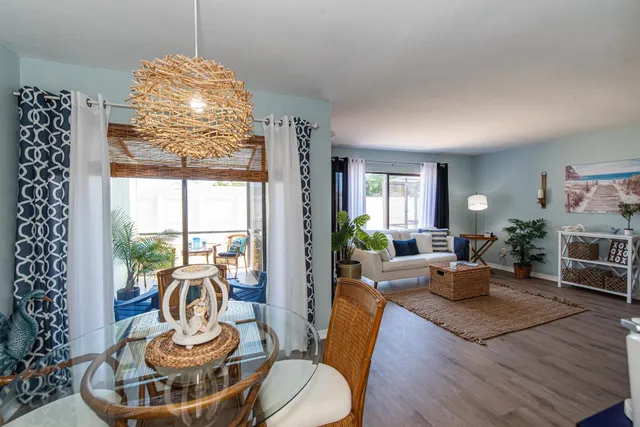 a living room with furniture a chandelier and a large window