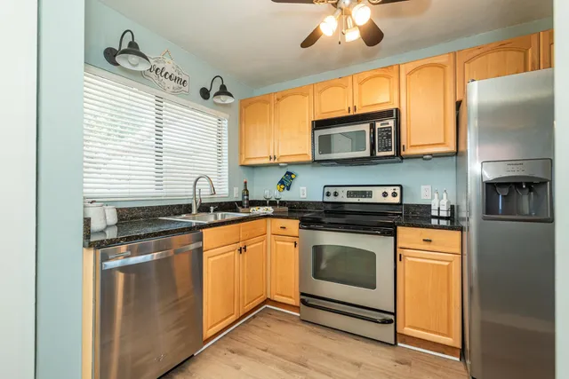 a kitchen with stainless steel appliances granite countertop a refrigerator a stove top oven a sink and dishwasher