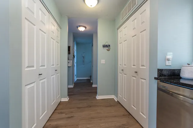 a view of a hallway with dining room and wooden floor