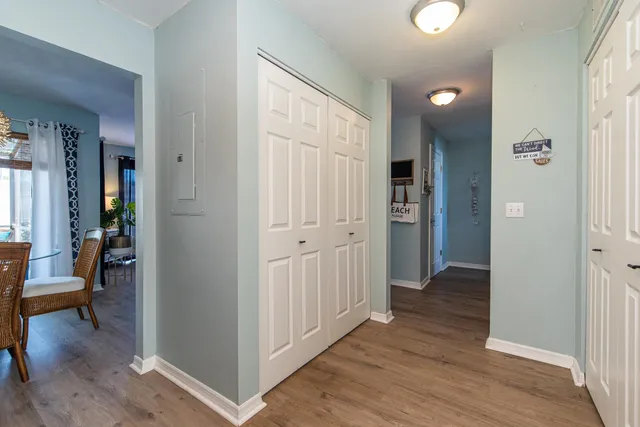 a view of a hallway with wooden floor and closet