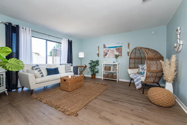 a living room with furniture a window and a wooden floor