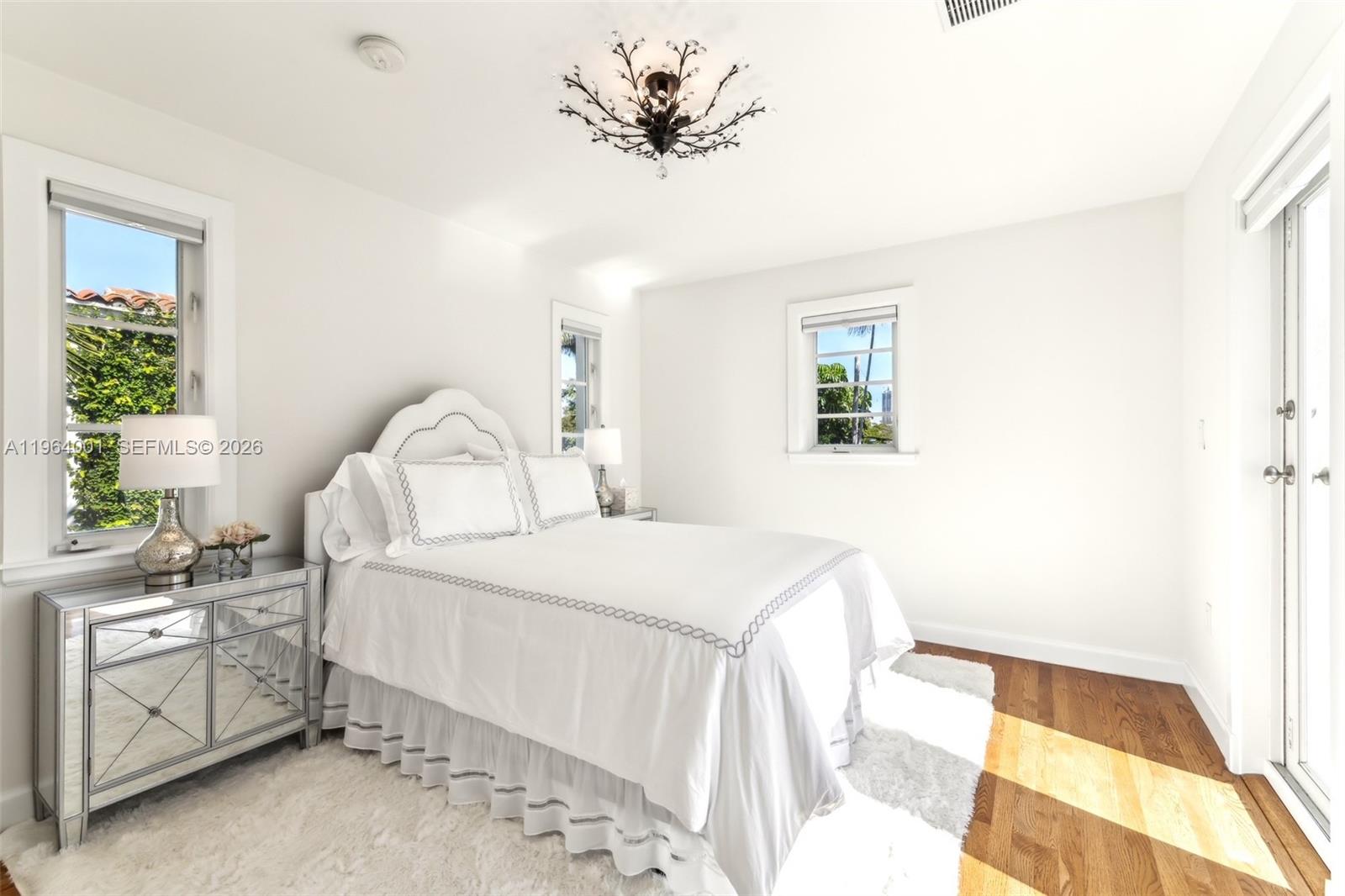 5711 North Bay Road Miami Beach, FL 33140 - Photo 11 of 14 a bedroom with a bed and a chandelier