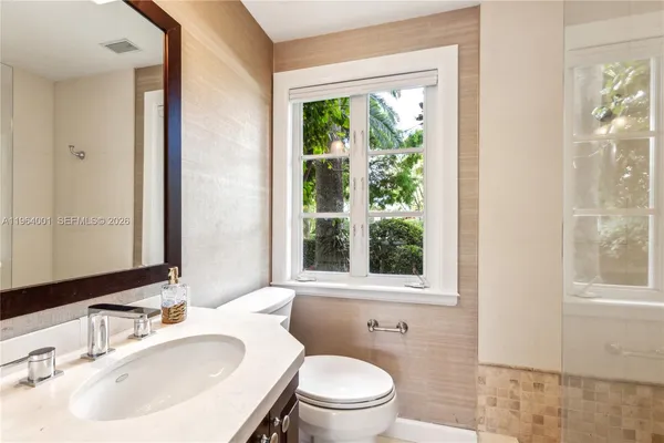 a bathroom with a sink toilet and a mirror