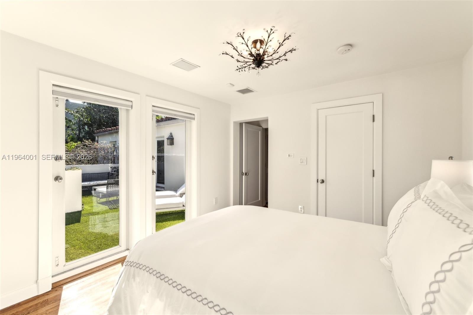 5711 North Bay Road Miami Beach, FL 33140 - Photo 13 of 14 a bedroom with a bed and a chandelier