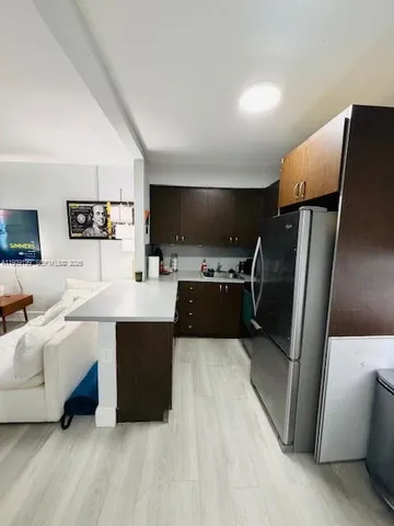a kitchen with stainless steel appliances a refrigerator sink and microwave